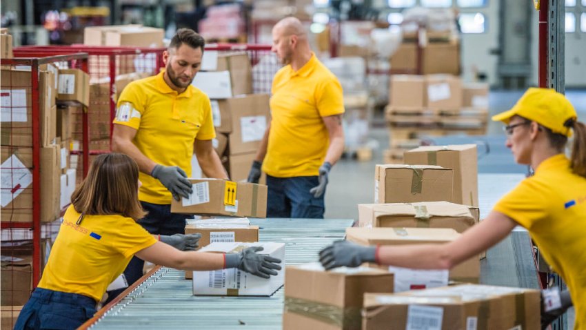 Group of employees handling shipments at a delivery warehouse