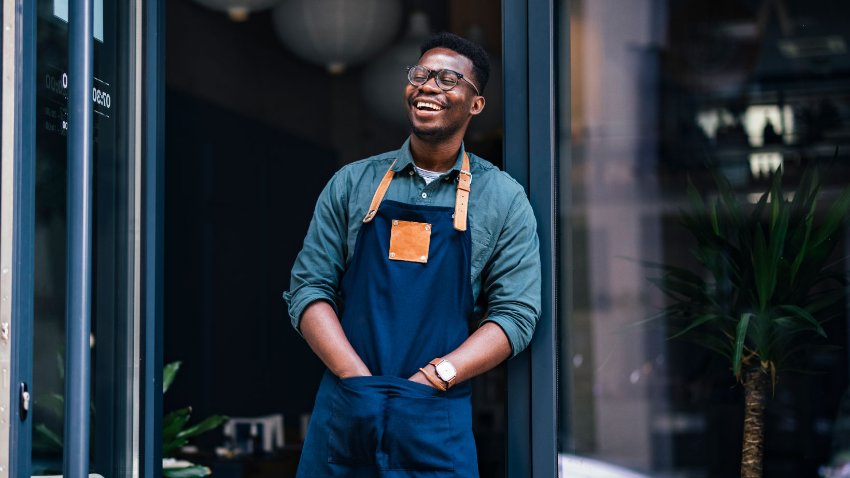 A man standing outside shop with a smiling face