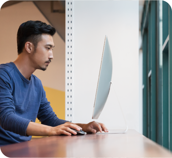 A young man working on a computer at workplace