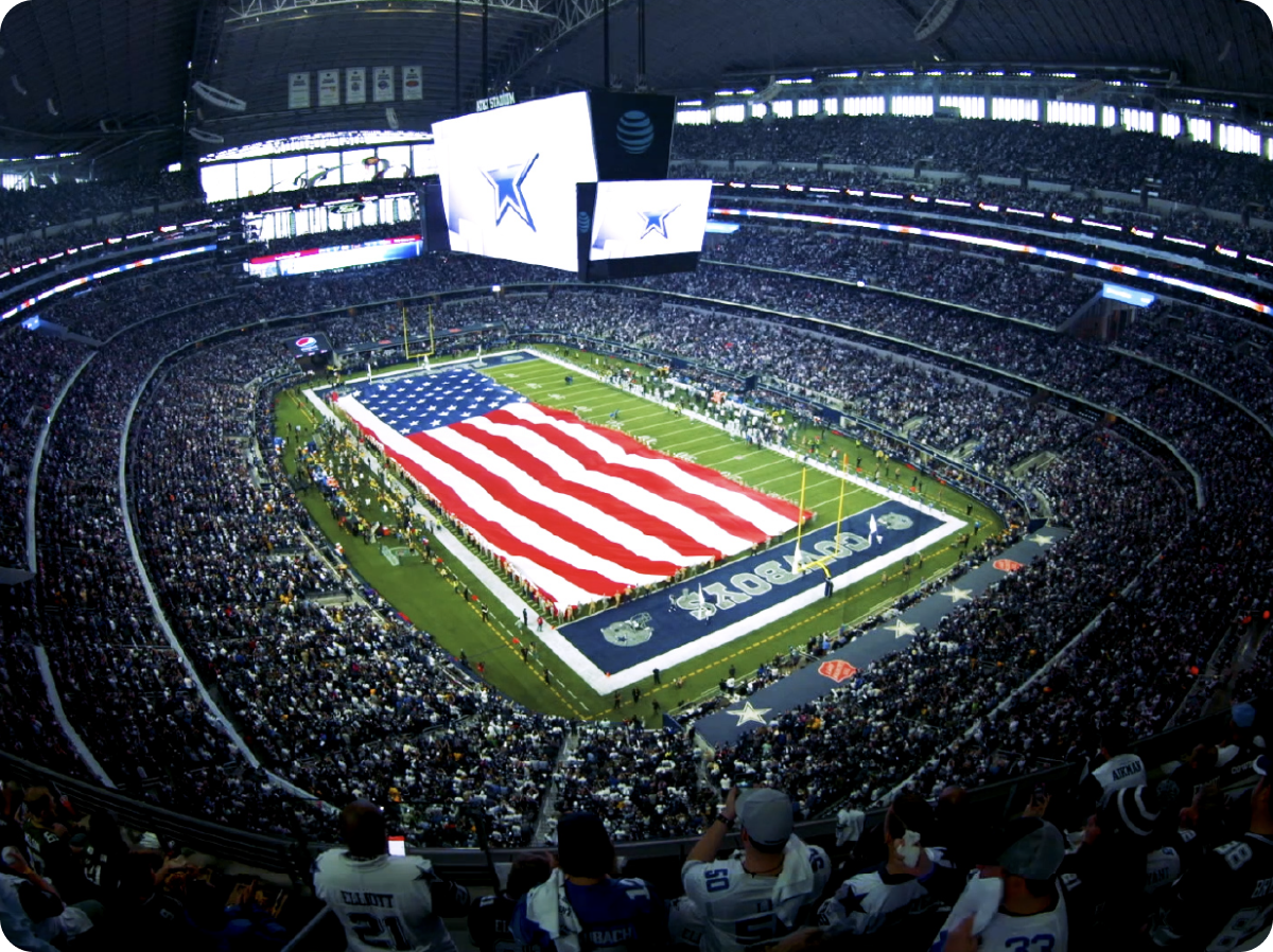 A football stadium with full of people and an American Flag