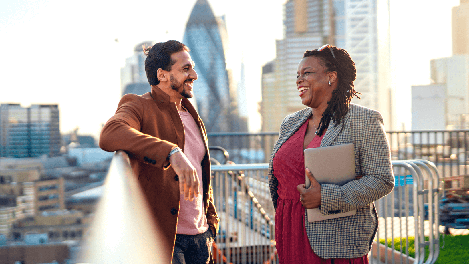 A man and a woman talking to each other with the view of skyscrapers in the back