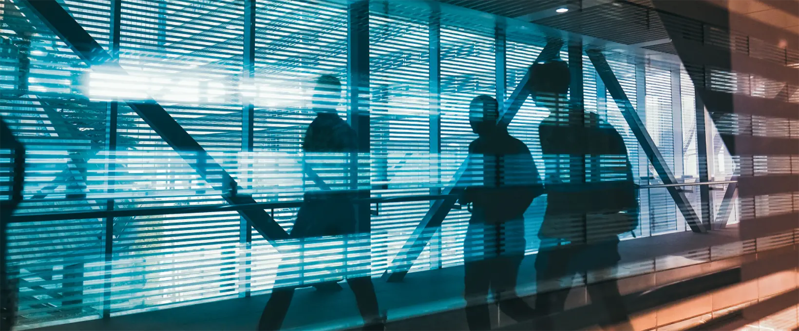 Three office workers walking through a skyway