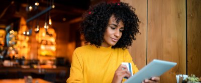 Woman using a credit card to pay for a purchase on a tablet