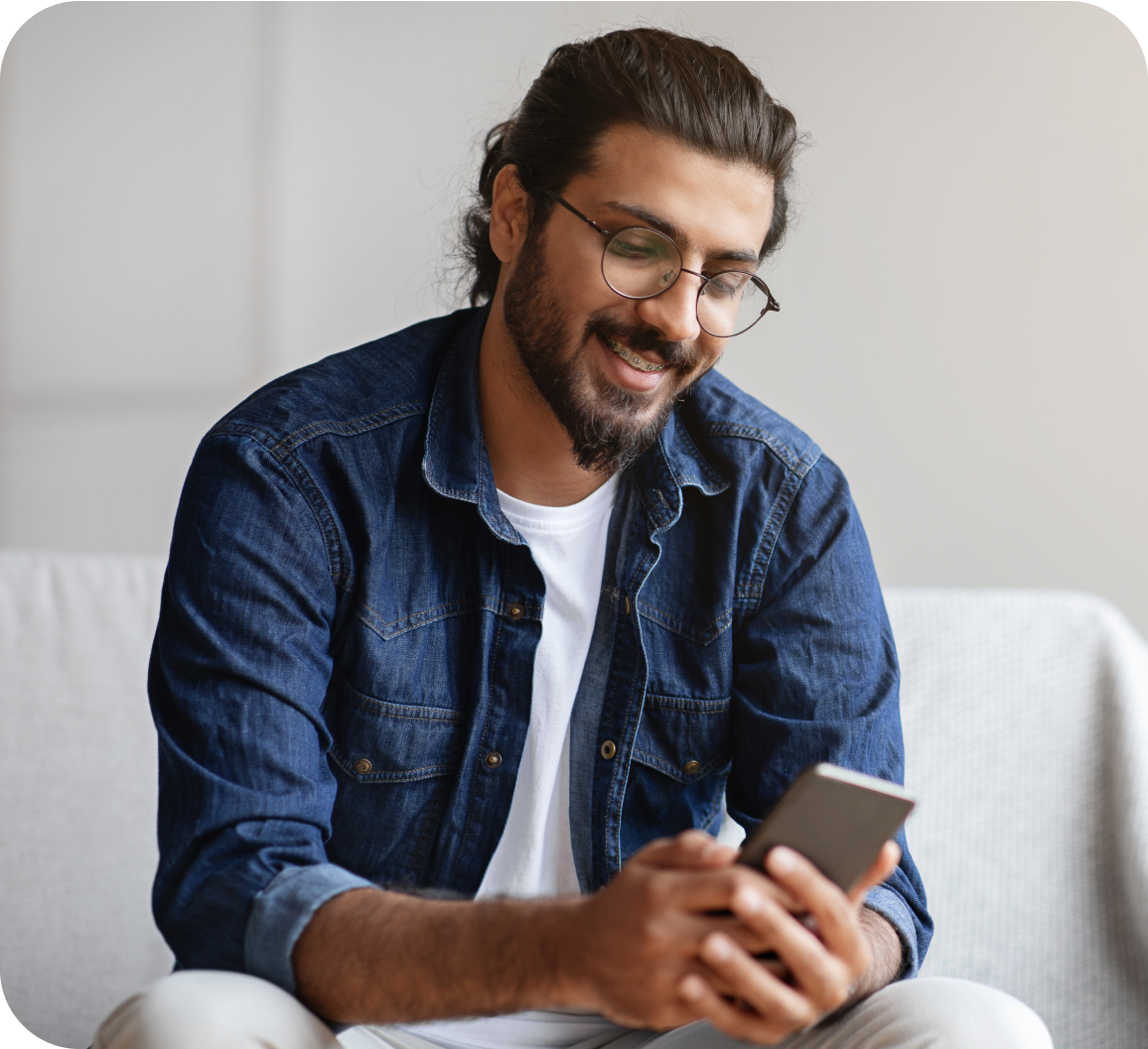 A gentleman in a blue shirt looking at a phone screen