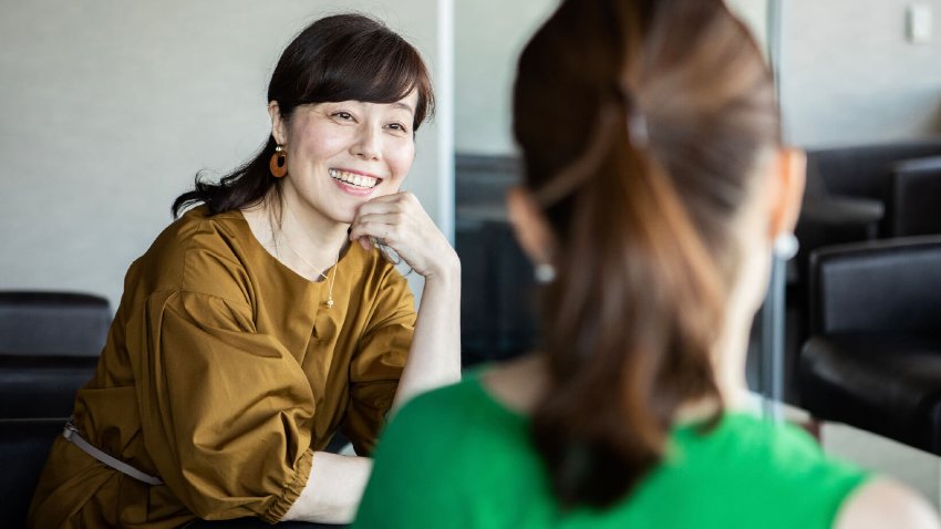 Two young women discussing in a meeting