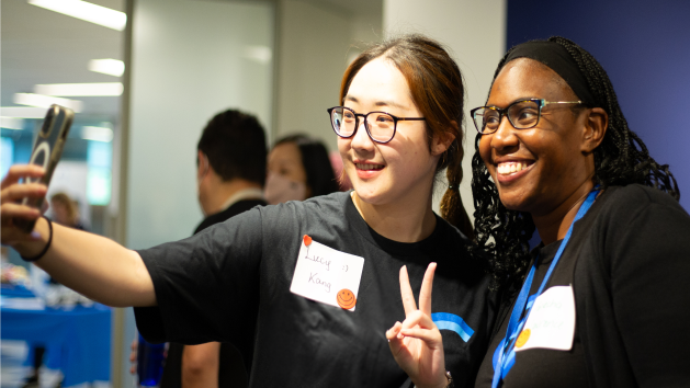 Two young professionals taking selfies at Dayforce event