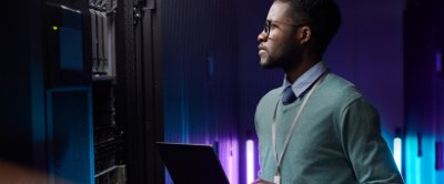 Man dressed in business attire working on a laptop in a datacenter