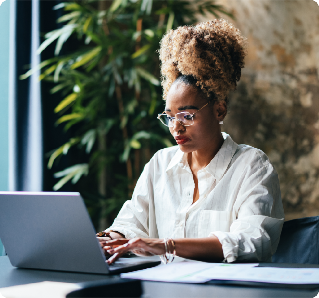 A picture of a woman working on a laptop in office