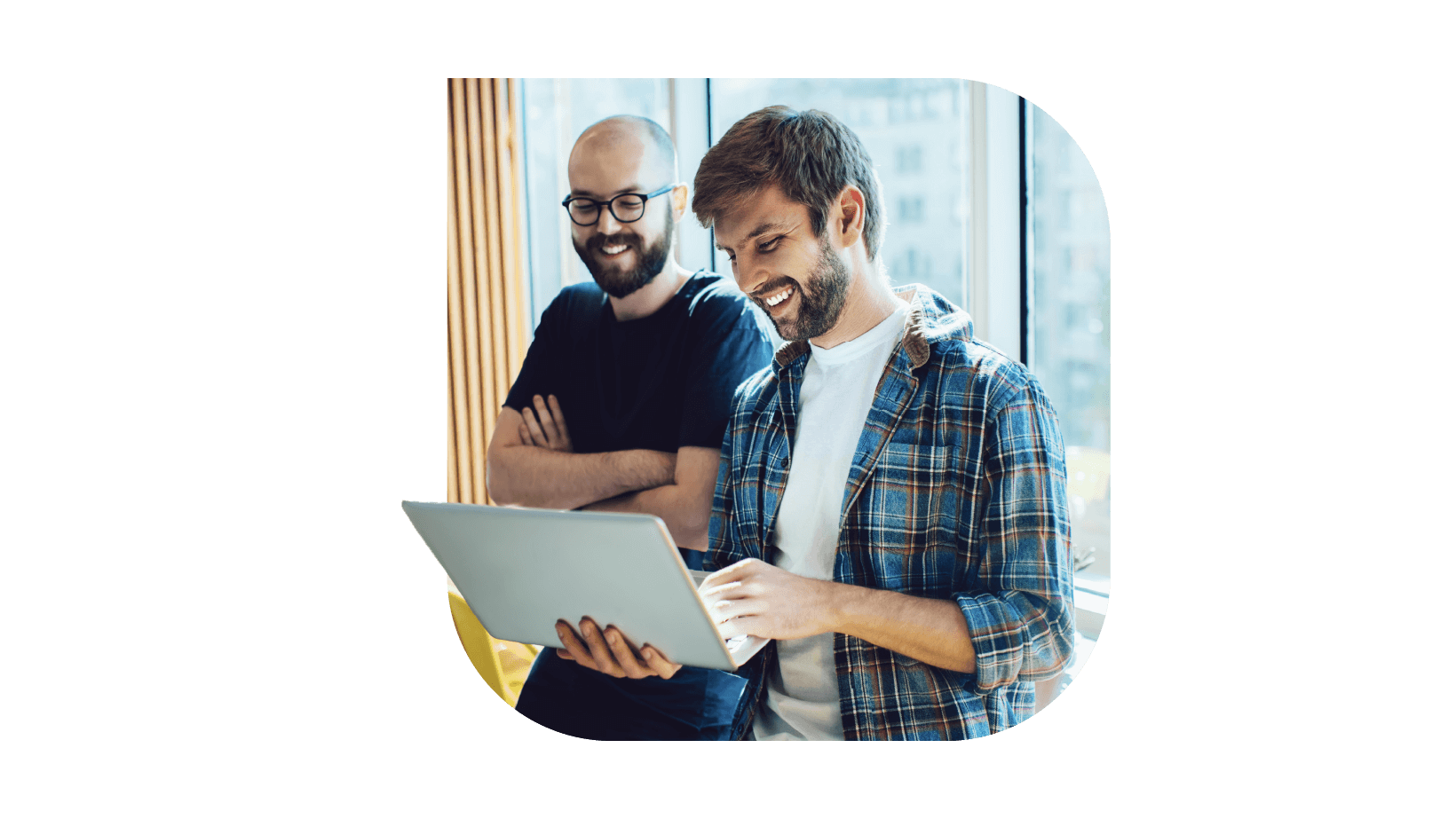 Two office employees looking at the laptop screen with a smile