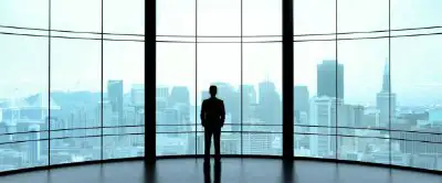 Man admiring the cityscape out the window of a tall building