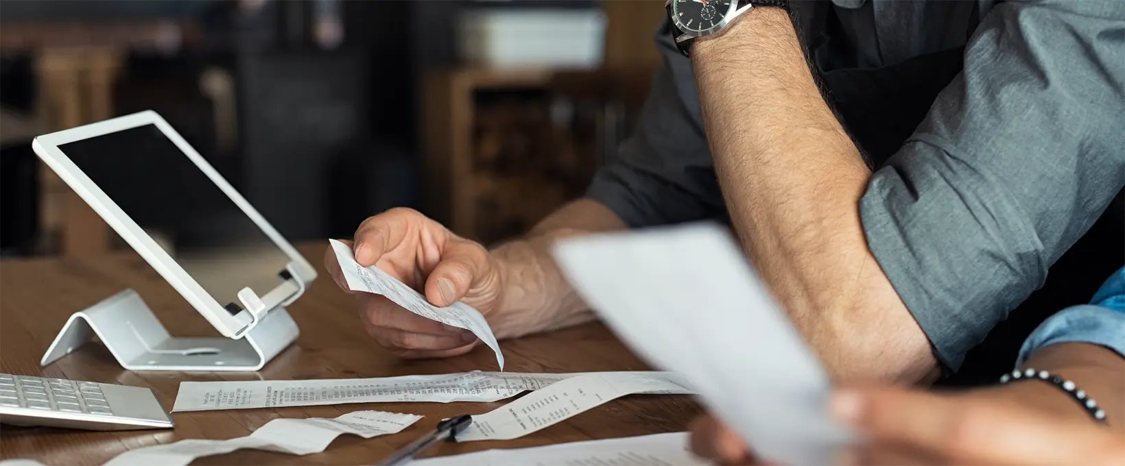 Man and woman reviewing receipts in front of a tablet
