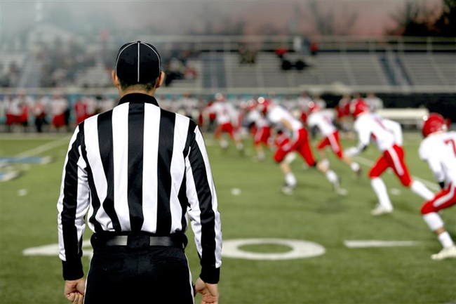 A Football referee and football players on the field